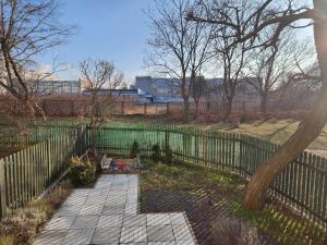 a fence in front of a garden with a sidewalk at Przymorze Apartament in Gdańsk