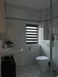 ファーレルにあるMeedehof Moorhausen, WH Kuhstallのトイレと洗面台を備えた白いバスルーム