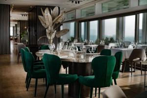 una sala da pranzo con un tavolo e sedie verdi di Metropol Palace, Belgrade a Belgrado