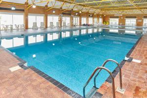 a large swimming pool with blue water in a building at Beach gardens in Greatstone