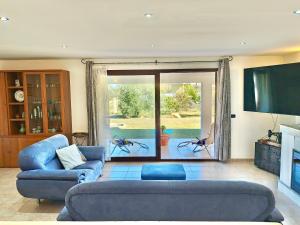 a living room with a blue couch and a television at Villa IS CARCURIS Jennas in Cardedu +48 photos