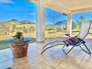 a chair and a table on a porch with a view at Villa IS CARCURIS Jennas in Cardedu