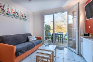 ein Wohnzimmer mit Sofa und Tisch in der Unterkunft Maison Village Port-Bourgenay in Saint-Hilaire-de-Talmont