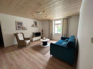 a living room with a blue couch and a table at La p'tite camargue in Le Crotoy