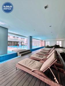 a pool with a row of beds in a building at Experience Elegance at Chambre Honore in Iloilo City