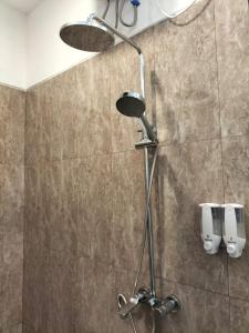 a shower with a shower head in a bathroom at Alit Guest House in Uluwatu +32 photos