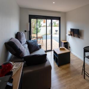 a living room with a couch and a table at Chez LilYves - Studio avec terrasse privée in Bouray-sur-Juine