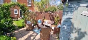 a patio with chairs and a table and a fence at Quirky Victorian three bedroom terraced house in Eastleigh