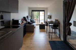a kitchen and living room with a couch and a table at Chez LilYves - Studio avec terrasse privée in Bouray-sur-Juine