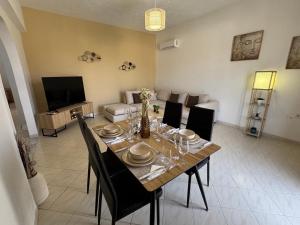 a dining room with a table with chairs and a television at V&G Cozy Home near Lindos, Spacious 2BR in vlicha