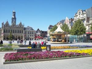 Petit Chalet في سانت كونتان: ساحة مدينة بها حديقة بها أزهار ودولاب دوار