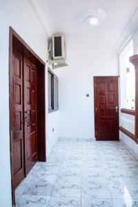 an empty hallway with two doors and a tiled floor at La Marina 2 in Cotonou +13 photos