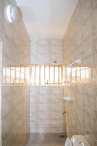 a bathroom with a shower and a toilet at La Marina 2 in Cotonou