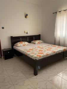 a large bed in a room with a bed frame at La Marina 2 in Cotonou