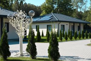a building with a sculpture and trees in front of it at Kintų Perlas Villa 4A in Kintai