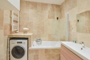 une salle de bain avec une machine à laver et un lavabo dans l'établissement VIEUX MURS - Brand new flat for 4, AC, WIFI center old Antibes, à Antibes
