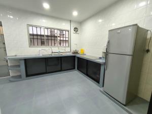 a kitchen with a refrigerator and a sink at Cozy Homestay near Pantai & Aeon Big - 10pax by Ngio in Batu Pahat