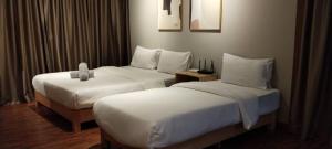 コタキナバルにあるK Avenue by Kansayan Homestayの白いシーツが敷かれたベッドが2つあるホテルの部屋