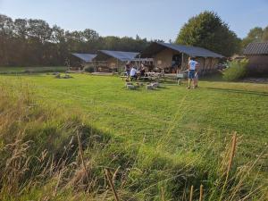a group of people standing in a field with a tent at Mooirust in Leersum