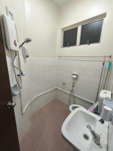 a bathroom with a sink and a toilet at Cozy Homestay near Pantai & Aeon Big - 10pax by Ngio in Batu Pahat +14 photos