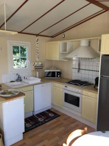 a kitchen with yellow cabinets and white appliances at Escale vendéenne in Brem-sur-Mer