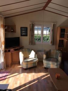 a living room with two chairs and a television at Escale vendéenne in Brem-sur-Mer