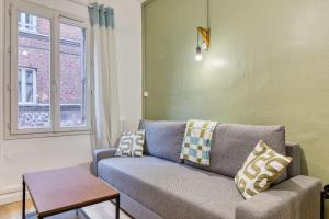 a living room with a couch and a window at Loulou maison de ville sur 4 niveaux au coeur de ville in Rouen