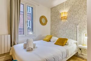 a bedroom with a white bed with yellow pillows and a window at Loulou maison de ville sur 4 niveaux au coeur de ville in Rouen