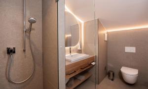 a bathroom with a shower and a sink and a toilet at Hotel Königgut in Wals +76 photos