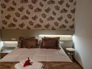 a bedroom with a large bed with a red rose on it at La Flor del Cantábrico in Ribadeo +48 photos