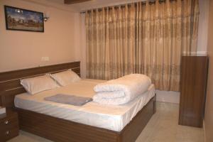 Un dormitorio con una cama con toallas. en Hotel Resunga & Thakali Kitchen, en Bhaktapur