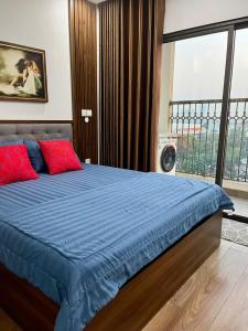 a bedroom with a bed with blue sheets and a window at HT Home D'el Dorado 4 in Hanoi