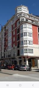 a large building with cars parked in front of it at La Flor del Cantábrico in Ribadeo