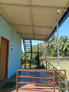 a porch with a wooden bench under a roof at Royal Home Stay Honnavar in Kāsarkod