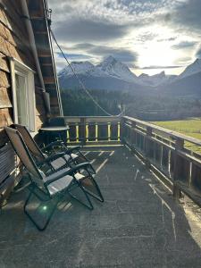 a rocking chair on a porch with a view of mountains at Beautiful Villa in Isfjorde in Isfjorden
