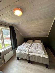 a bed in a small room with a window at Beautiful Villa in Isfjorde in Isfjorden