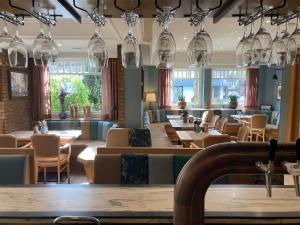 a restaurant with many tables and chairs and chandeliers at Hotel Paulsen in Zeven