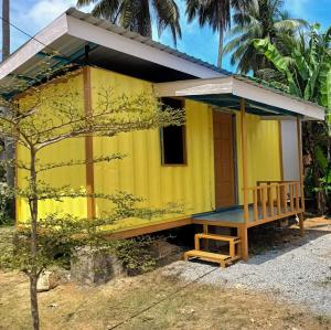 a yellow house with a bench in front of it at PS Din Kontenastay in Kota Bharu