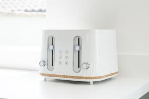 a white toaster sitting on a kitchen counter at Glasswing Stays Newbiggin Beach House in Newbiggin-by-the-Sea