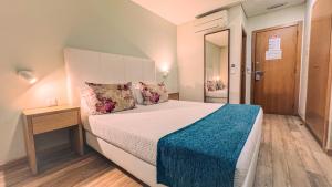 een slaapkamer met een groot bed en een blauwe deken bij Sea Garden Peniche in Peniche