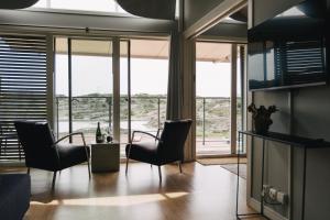 a living room with chairs and a table and windows at Björholmen Hotell & Restaurang in Björholmen