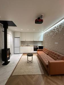 a living room with a brown couch and a kitchen at Nordic Bliss Apartment 1 in Inari