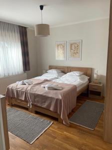 a bedroom with a bed and two mats on the floor at Alice Vendégház in Kalocsa
