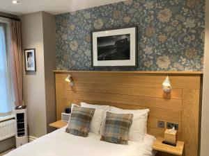 a bedroom with a bed with a wooden headboard at The Black Hat in Ilkley