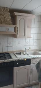 a small kitchen with a sink and a stove at Ferienwohnung Bienchen in 04680 in Colditz