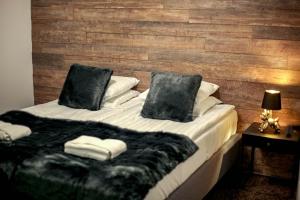 a bedroom with a bed with a wooden wall at Lapland Dream House in Ivalo