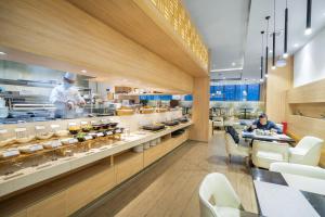 a restaurant with two chefs preparing food in a kitchen at Victoria Hotel Guangzhou Zhujiang New Town in Guangzhou