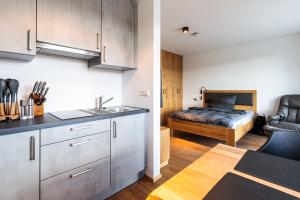 a kitchen and living room with a bed in the background at Ferienwohnung Stadtblick 8 in Pfullendorf