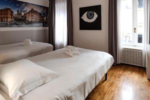 a bedroom with two beds with towels on them at Restart Accommodations Dea Roma in Rome