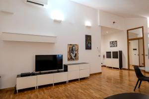 a living room with a flat screen tv on a white wall at Restart Accommodations Dea Roma in Rome
